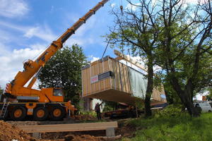  Die Casa Invisibile wird vom Schwerlastkran auf Punktfundamente abgelassen, die UK für die Fassade ist bereits angebracht
 