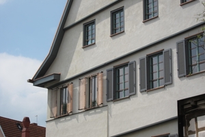  Die Fassade erhielt neue Fenster mit Öffnungsflügeln. Im komplett neuen Treppenhaus aus Beton (links) sind Festverglasungen und stilisierte Klappläden 