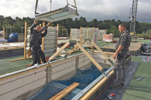  Für die Montage der Sattel-Lichtbänder wurden zunächst die beiden ersten Elemente des Oberlicht-Systems per Kran über die Dachöffnung gehoben und mit Hilfe zweier Hilfssparren exakt fixiert und montiert  Fotos: Velux 