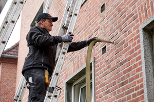  Mit Druckluft wird das flexible ?Fillrock KD? Dämmgranulat in den Hohlraum zwischen Außenwand und Vormauerwerk geblasen. Rund 90 m3 Granulat wurden von den Mitarbeitern der Dachfit GmbH in weniger als einer Woche in die Außenwände von drei Mehrfamilienhäu 