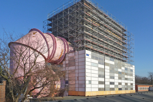  Nach Einrüstung der mehrgeschossigen Laborhalle konnte deren Fassade aus Stahl-Sandwichelementen mit einer Sonde im Wirbelstromverfahren untersucht werden. Das Ergebnis führte zum kompletten Austausch der alten grauen Sandwichelemente gegen neue, im urspr 