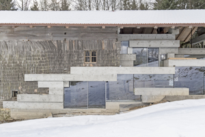  In der Seitenansicht gut zu sehen: der Übergang in der Fassade von Holzschindeln zu Glas und Beton 