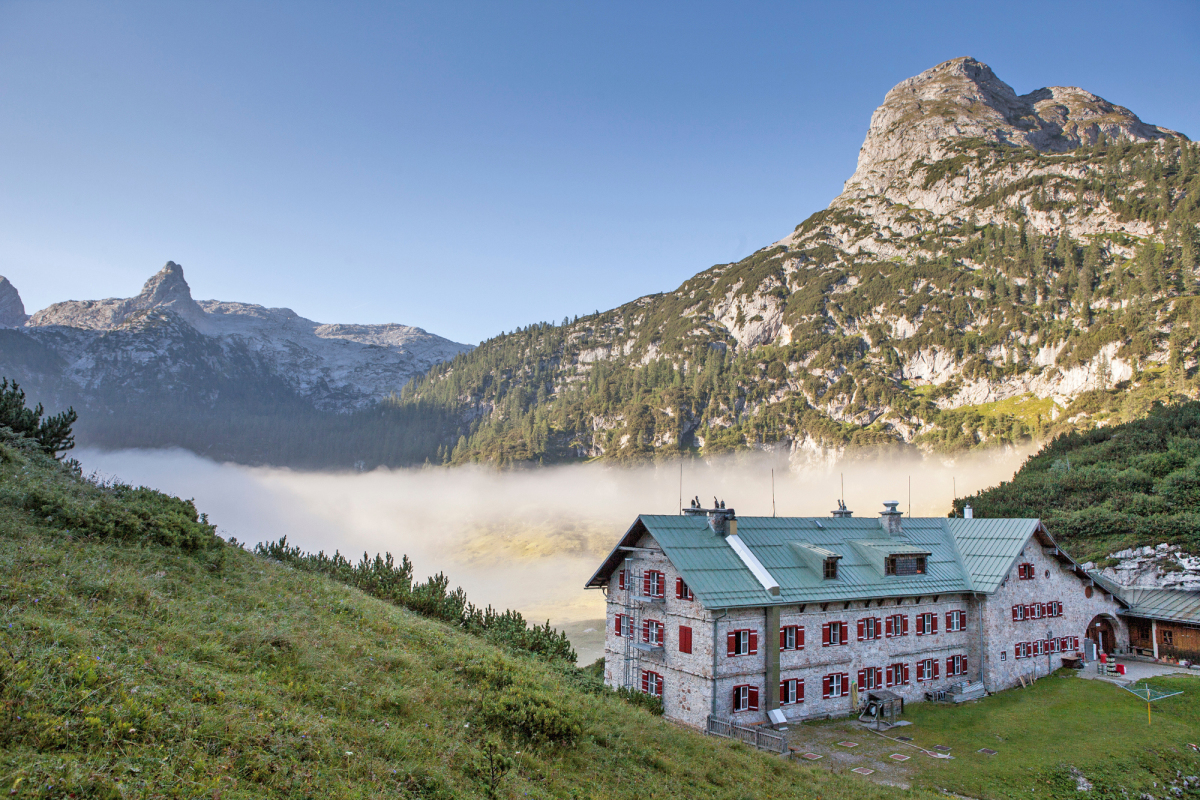 Das Kärlingerhaus mit den frisch gestrichenen Fensterläden vor einer vom Funtensee aufsteigenden Nebelbank