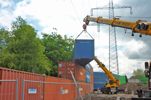  Wegen der nahen Hochspannungsleitung wurden die Container an der Emscher von zwei Krähnen gestapelt 