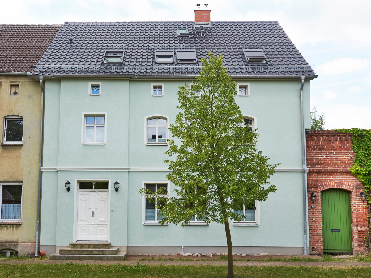 Auf der Straßenseite blieb das historische Bild mit der typischen alten Teilung der Fenster und dem grünen Putz erhalten