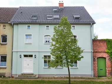 Auf der Stra?enseite blieb das historische Bild mit der typischen alten Teilung der Fenster und dem gr?nen Putz erhalten