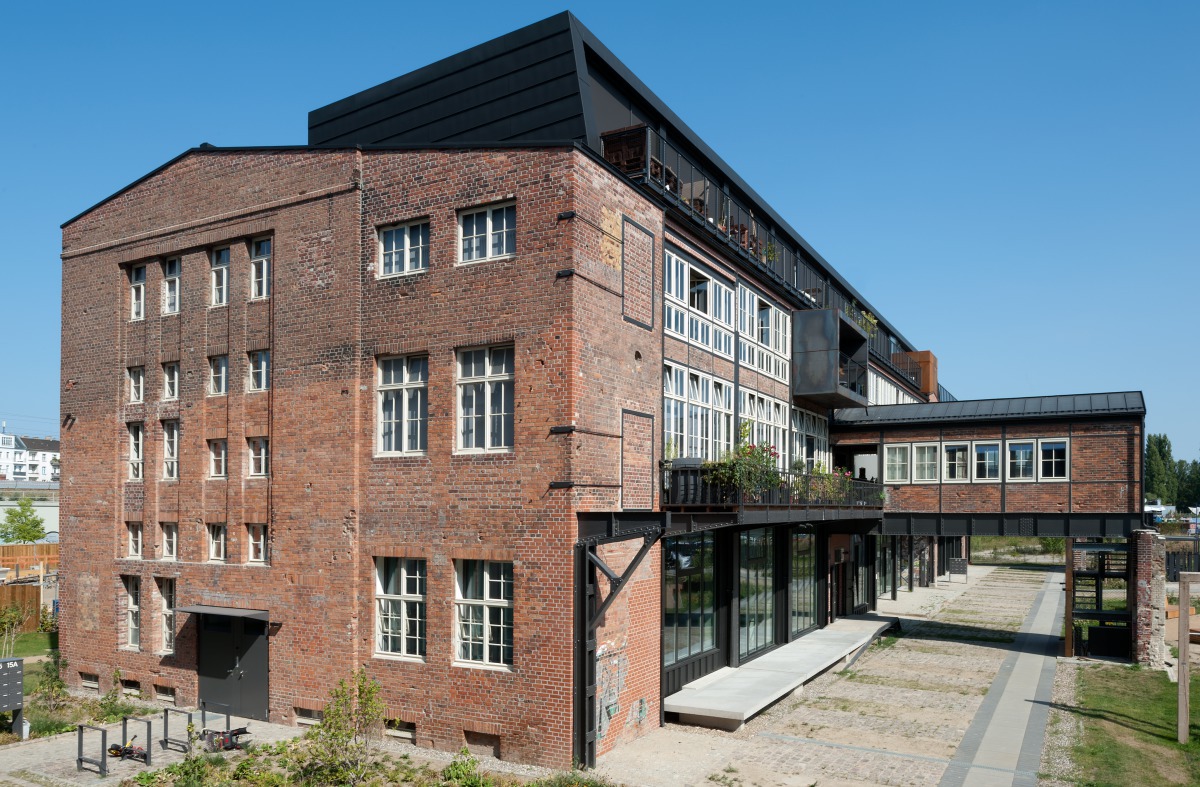 Auf der östlichen Seite der ehemaligen Glashütte Alt-Stralau konnte ursprünglich ein Verladezug das Werkstattgebäude unterqueren. Die Brückenbauten werden heute als Zugang zu Wohnungen und als Wintergarten genutzt Foto: Udo Meinel