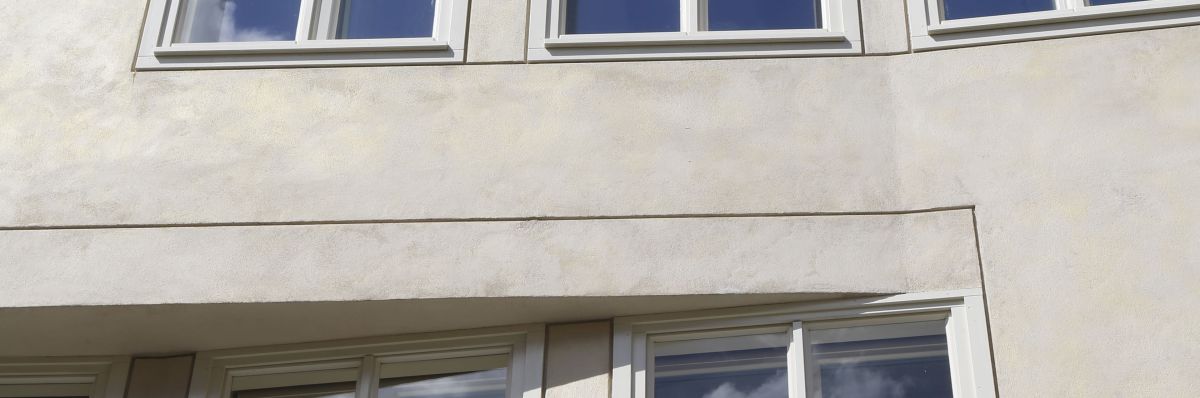 Die b?ndig in der Fassade liegenden, hellgraugr?n lackierten Kastenfenster, werden durch eine feine Putzlineatur umfasst