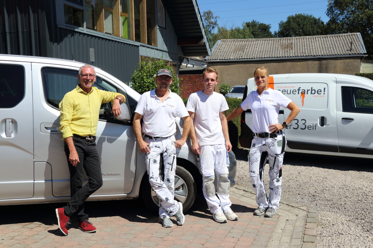 Volker Kempen (links) und sein Team von „neuefarbe!“ vor dem Testwagen, einem Nissan e-NV200 mit einer Reichweite von 275 Kilometern und 80 Kilowatt starkem Elektroantrieb