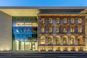  Die neoklassizistische Bestandsfassade wird vom Neubau mit seiner Glas- und Sandsteinfassade eingerahmt 