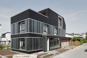  Dass es sich um ein Haus aus Recyclingmaterialeien handelt, ist schon von Weitem an der Fassade zu sehen: Profilbauglas aus einer alten Lackiererei, Holz von Saunabänken und schwarz beschichtete Faserzementplatten vom ehemaligen evangelischen „Haus der Ju 