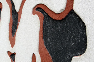  Detail der Sgraffito-Fassade. Die unterste Schicht ist schwarz, die mittlere rot und die oberste weiß 