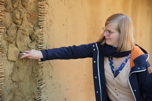  Lisa Stratmann, stellvertretende Museumsleiterin, streicht den Lehm mit der Kelle glatt. 