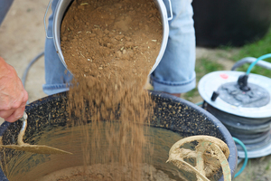  Die Anwendungstechnikerinnen der Firma Tierrfino rühren den Lehm in  einem Mörtelkübel mit Wasser an.  Die breiige Masse muss dann kurz ruhen<span class="bildnachweis">Fotos: Michaela Podschun</span> 