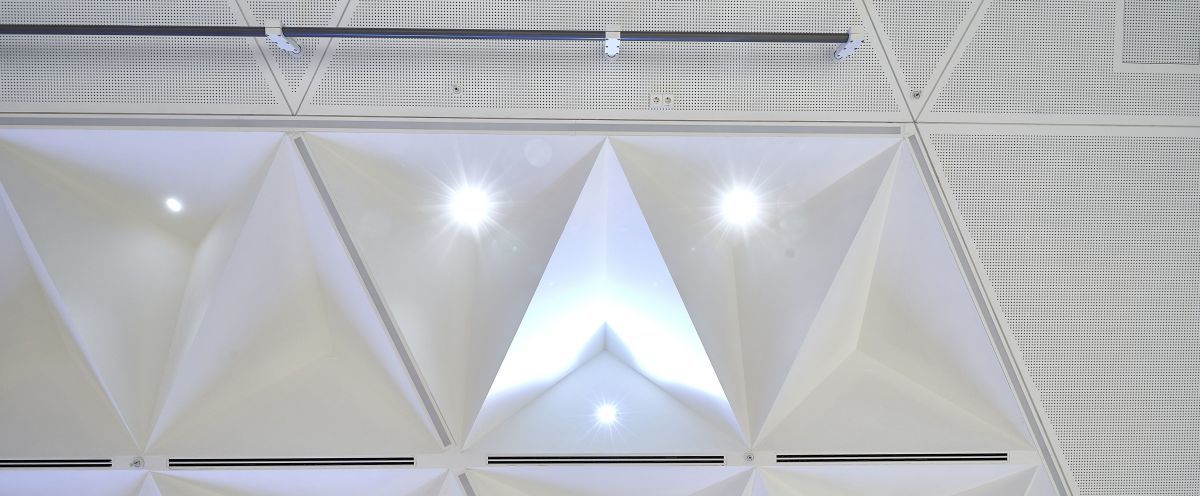 Die Dreiecksfelder der Decke in Saal 4 sind als gelochte Akustikdecke mit „Knauf Cleaneo Platten in 8/18 Rundlochung“ ausgef?hrt