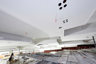 Die horizontalen Absorptionsflächen der Deckenkoffer im Großen Saal 1 sind mit „Knauf Cleaneo Akustikplatten“ ausgeführt, während die vertikalen Reflexionsflächen aus glatten Gipsplatten bestehen