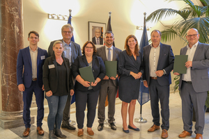  Die Parlamentarische Staatssekretärin beim Minister für Ernährung und Landwirtschaft, Dr. Ophelia Nick (3. v. r.) übergab in Berlin die Förderbescheide für Konzeption und Bau einer Pilotanlage zur Herstellung klimafreundlicher Ziegeldämmstoffe mit Buchenholzfasern. Von links: Markus Baumann und Kathleen Flotow (Projektmanagement und Baufachberatung der FNR), Gunther Mieth (BMEL), Nina Ritter (Fraunhofer WKI), Murray Rattana-Ngam (Gesellschafter und Geschäftsführer im Ziegelwerk Bellenberg), Dr. Ophelia Nick (BMEL), Hubertus Loick (Vorstandsvorsitzender - Loick AG für nachwachsende Rohstoffe), Klaus Schuppan (Geschäftsführer - Loick Biowertstoff GmbH).  