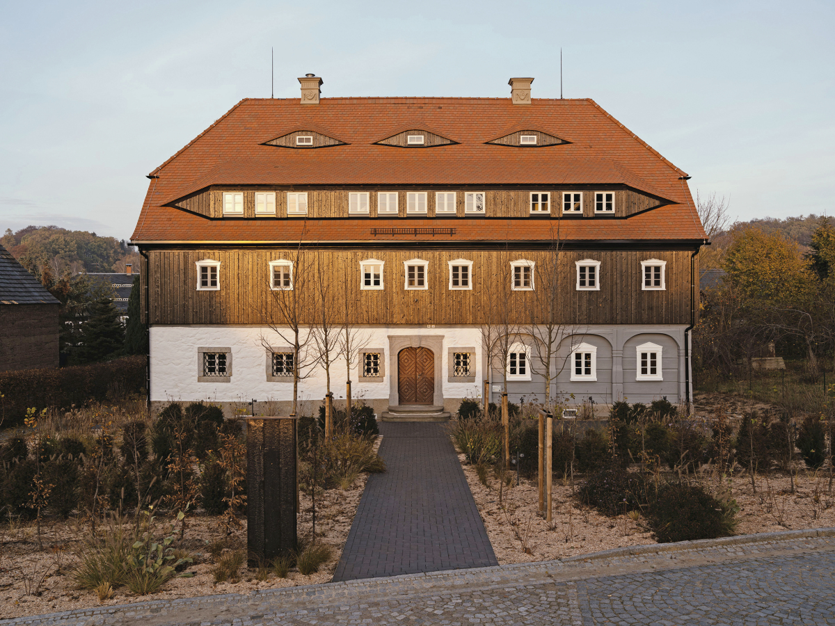 Neu hinzugekommen sind außen an dem nach Plänen des Architekturbüros Atelier ST umgebauten und sanierten Umgebindehaus in Schönbach die Hechtgaube im Dach und die Fassadenbekleidung aus karbonisierten Brettern am Obergeschoss