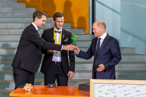  Während eines Empfangs der Deutschen Berufe-Nationalmannschaft sprach der Bundeskanzler mit den beiden Weltmeistern Marvin Schuster und Philipp Raab über ihren Wettkampf bei der WM der Berufe in der Disziplin Robot Systems Integration und das Thema Robotik 