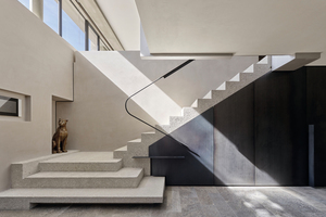  Vom Entree führt eine skulptural ausgeformte Treppe hinauf ins Atelier 