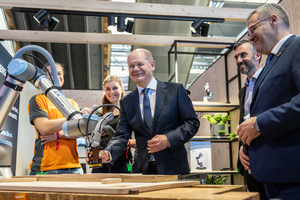  Bundeskanzler Olaf Scholz besuchte beim Live-Event Zukunft Handwerk den Stand von J+H Robotik. Zwei junge Handwerker erklären den Einsatz von Robotik, Digitalisierung und Automation anhand eines Roboterarmes im Schreinerhandwerk 