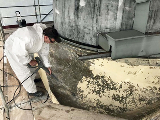 Zunächst befreiten die Handwerker die Fassade von Algen und Verschmutzungen mit einem Wasserstrahlgerät