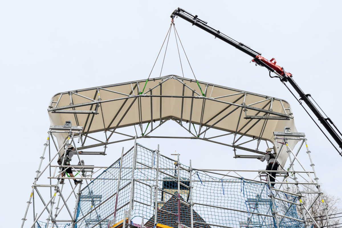 Die erste, 2,50 m breite und knapp 10 m lange Dacheinheit wird auf die Ostseite eingehoben