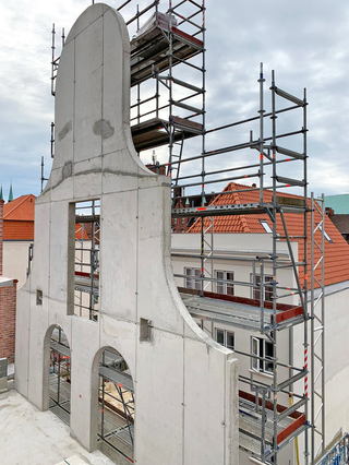 Der Schmuckgiebel ist über eine Höhe von 10,50 m freistehend. Er musste mit all seinen Rundungen und Öffnungen als eine Scheibe geschalt und betoniert werden