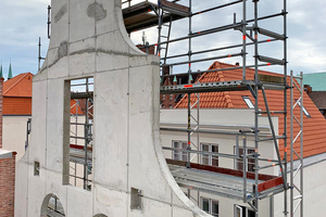  Der Schmuckgiebel ist über eine Höhe von 10,50 m freistehend. Er musste mit all seinen Rundungen und Öffnungen als eine Scheibe geschalt und betoniert werden 