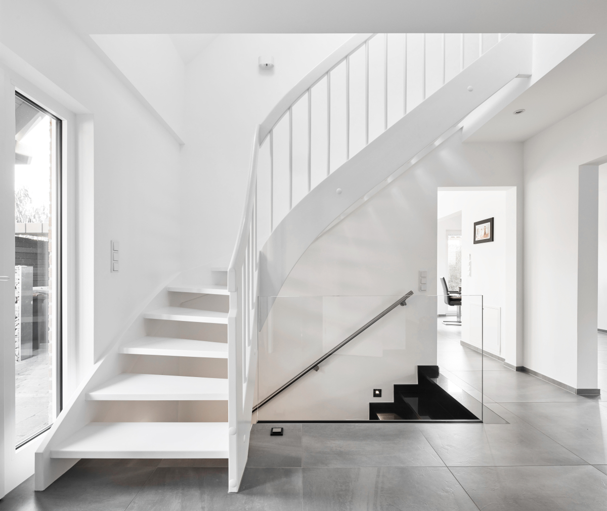 Elegante Leichtigkeit: Die weiße Treppe fügt sich optisch in den Raum ein und ist dank der schimmernden Oberflächen ein echter Hingucker
