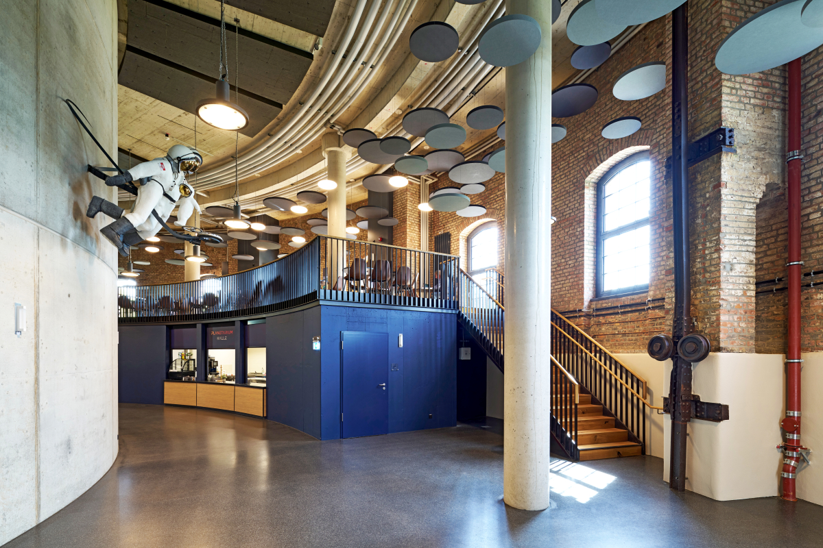Der innere Stahlbetonzylinder mit dem Kuppelraum wird vom hohen, luftigen Foyer umgeben, das auch das Café und Ausstellungsbereiche aufnimmt