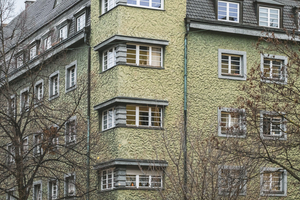  An der viergeschossigen Großwohnanlage entlang der Münchner Pilgersheimerstraße wurde ein Strukturputz mit halbkreisförmigen Handbewegungen als schneckenartige Struktur ausgeführt 