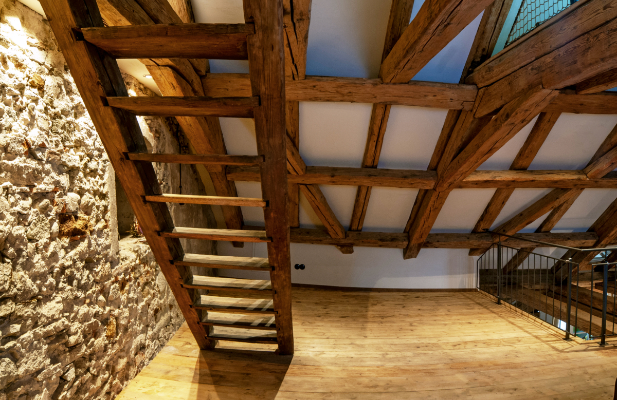 Die Kontraste aus altem Gebälk, Bruchsteinmauerwerk, warmen Holzböden und glatten Lehmputzoberflächen verleihen dem Loft seinen besonderen Charme