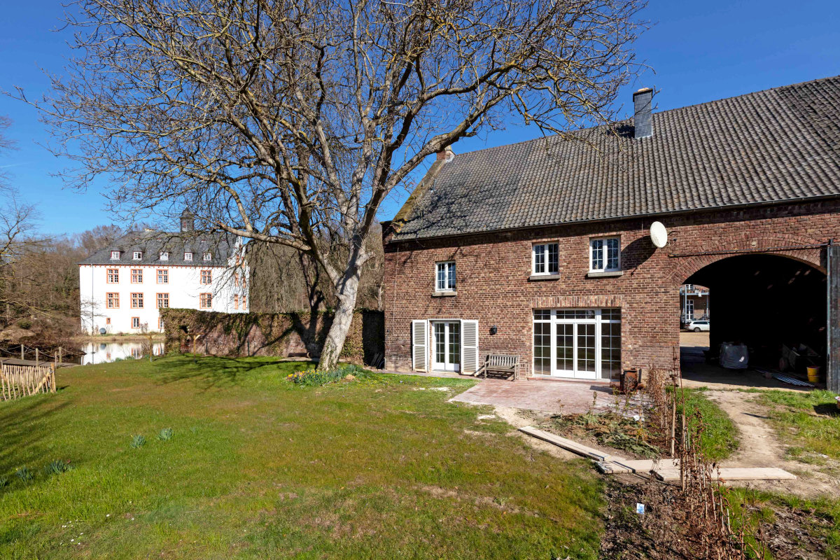 DieToreinfahrt des Herrenhauses mit der Wasserburg im Hintergrund