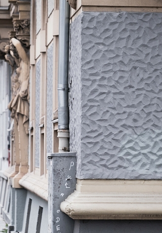 An der Fassade des 1898 in der Münchner Klenzestraße 105 erbauten Hauses finden sich im Erdgeschoss verputze Oberflächen mit einer ausgeprägten Scharfkantigkeit, wie sie bei Strukturputzen nur selten zu finden ist