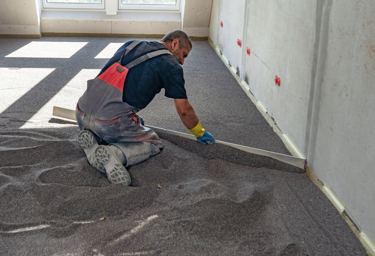 Der direkt auf der Holzbalkendecke aufgebrachte Schüttungsbinder wird von den Handwerkern mit einer Abziehlehre abgezogen
