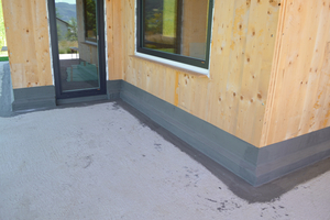  Auch am Sockel eines Holzhauses lässt sich eine mineralische Abdichtung verwenden. Sie hat mit ihrer betongrauen Farbgebung die passende, optisch ansprechende Farbe 