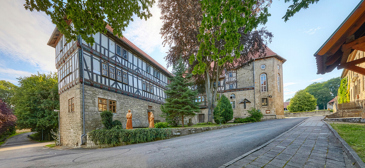 Fachwerkbauten von Kloster Anrode mit Kirche im Hintergrund