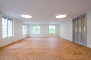  Der Aufenthaltsraum im zweiten Obergeschoss des Osttrakts mit revitalisiertem, historischen Fischgrätparkett und Holzfenstern 