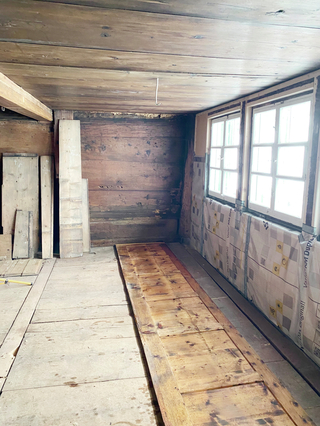 Verlegen des neuen Dielenbodens aus noch gutem Holz des alten Bodens und Dämmung der Außenwand mit Holzwolleplatten und Dampfbremse
