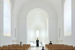  Heute ist der Kirchraum hell und licht, der Chorraum ist geöffnet und Altar und Bestuhlung sind gestalterisch reduziert 