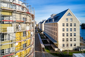  Die organisch geschwungenen Linien der kieselförmigen Neubauten (links im Bild) setzen einen Kontrapunkt zu den klaren Formen der historischen Speicher (rechts im Bild) 