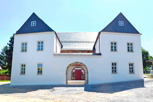  Das „Neue Schloss“ besteht aus einer zweigeschossigen Dreiflügelanlage, deren Hauptflügel ein Walmdach und in der Mitte ein Rundbogentor besitzt 