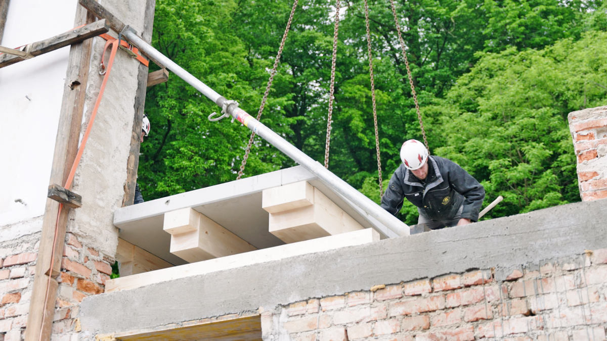 Detail Holzbalken auf Betonplatte geklebt, mit Aussparung für den Schornstein, Aussparungen für die Auflage auf dem Randbalken