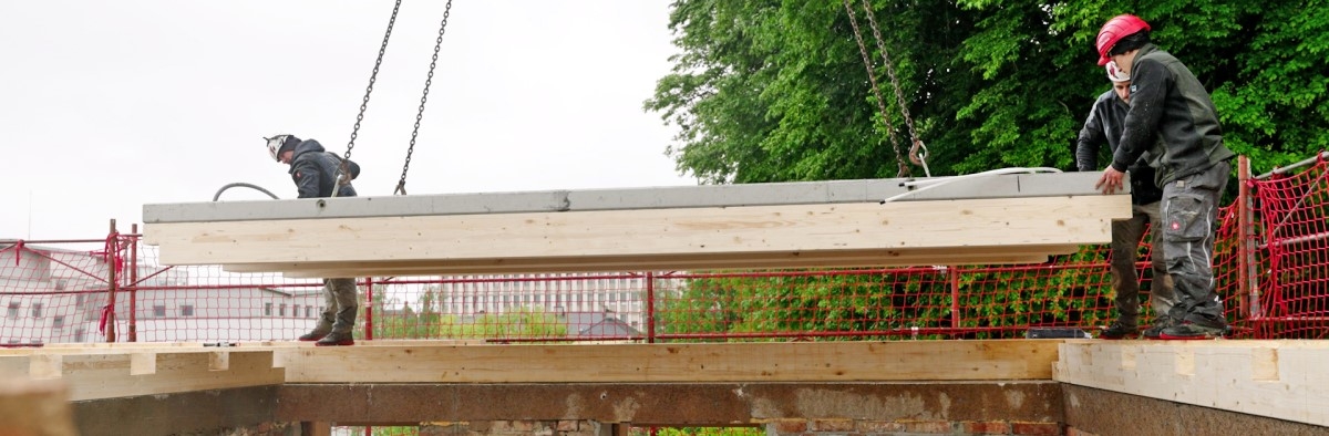 Einheben der HBV-Deckenelemente mit dem Kran. Die Elemente werden auf die Randbalken und hier in die dafür vorgesehenen Aussparungen eingehoben