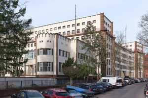  An der Fassade zeigt sich die expressionistische Gestaltung im Kontrast zu den weißen Putzflächen im Schmuck aus rotbraunen Terrakottasteinen 