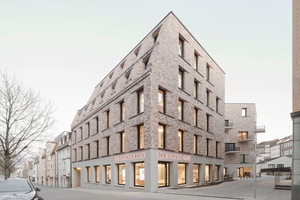  Von der Form wie eine Dachmansarde, vom Aufbau wie die Klinker-Fassade: Schräg abfallende Obergeschosse verleihen dem Gebäude zur Straßenseite hin Charakter  