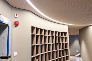  Das in die Akustikdecke eingelassene LED-Leuchtenband unterstreicht perfekt die geschwungene Form der Wand- und Deckenkonstruktion 