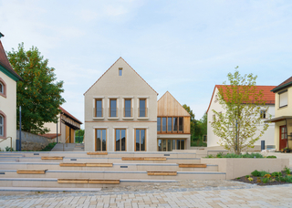 Der neue Dorfplatz in Niederwerrn. Links das ?Haus aus Stein? mit dem Bürgersaal, rechts das ?Haus aus Holz? mit dem Café im Obergeschoss
