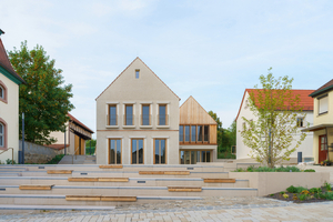  Der neue Dorfplatz in Niederwerrn. Links das ?Haus aus Stein? mit dem Bürgersaal, rechts das ?Haus aus Holz? mit dem Café im Obergeschoss 